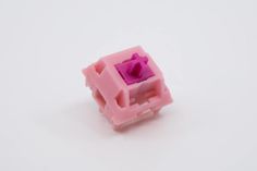 a small pink object on a white surface with no one in it's image