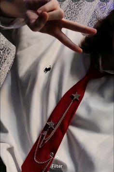 a woman in white dress laying on top of a bed with red tie and star brooch