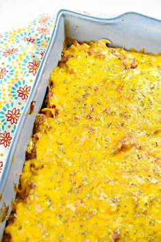 a casserole dish with cheese and other toppings in a blue baking pan