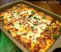 a casserole dish with sausage, cheese and parsley