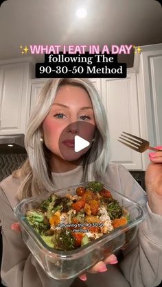 a woman holding a glass bowl filled with food