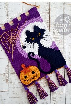 a crocheted halloween bag with a black cat on it