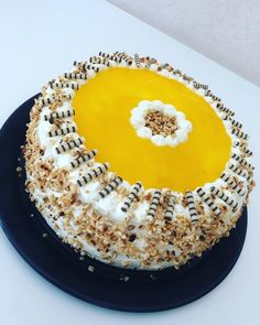 a cake with white frosting and black sprinkles sitting on a blue plate