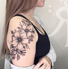 a woman with a black and white flower tattoo on her shoulder