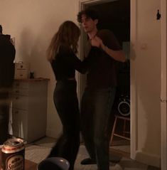 a man and woman dancing in the living room