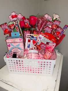 a white basket filled with lots of valentine's day items on top of a table