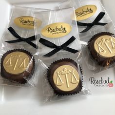 four chocolates wrapped in cellophane and tied with black ribbon on top of each other