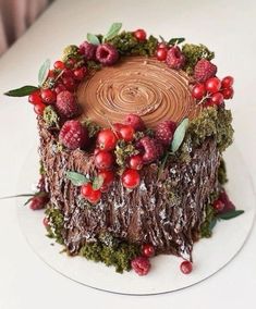 a chocolate cake decorated with berries and greenery