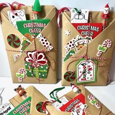 three christmas gift bags tied with twine and decorated with stickers, tags, and bows