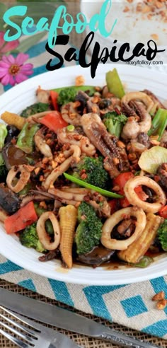 a white plate topped with stir fry and veggies on top of a blue checkered table cloth