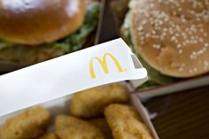 a box filled with chicken fingers next to a hamburger