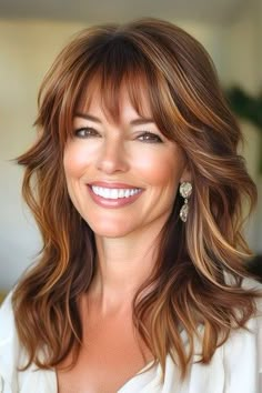 Save this pin for the best layered hair with bangs ideas. Soft waves cascade down into layered tiers in this stunning longer cut. Layered waves with piecey bangs offer a perfect mix of softness and structure, adding natural bounce and dimension to your hair. Long Tapered Layers Hairstyles, Over 50 Curtain Bangs, Long Layers In Shoulder Length Hair, Dark Layered Hair With Bangs, Full Bangs Layered Hair, Long Hair With Many Layers, Side Part Bangs Medium Hair, Mid Length Wavy Haircuts With Bangs, Long Wavy Layered Hair With Bangs