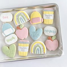 decorated cookies in the shape of rainbows, clouds, and hearts on a tray