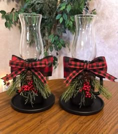 two glass vases with red and black bows on them