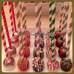 there are many candy covered straws on the table with red and white striped sticks