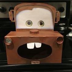 a cardboard box shaped like a toaster with eyes and mouth