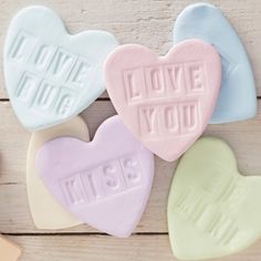 three heart shaped candys with the words i love you written on them next to two hearts