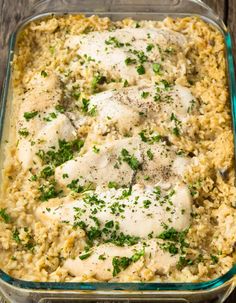 chicken and rice casserole with parsley in a glass dish on a wooden table