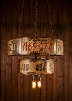 two light fixtures hanging from chains in front of a wooden wall with numbers on them