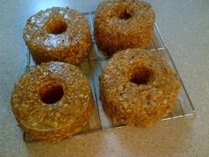 four doughnuts sitting on top of a glass rack next to eachother