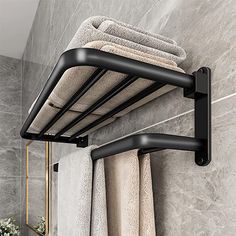 a towel rack in the corner of a bathroom with towels hanging from it's sides