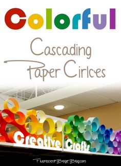 colorful paper circles are on display in the store's front window, and there is a large sign that says colorful cascading paper circles