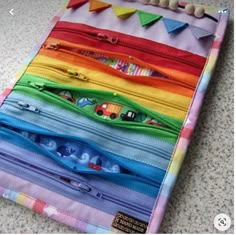 there are many different zippers on the table and one is multicolored with cars