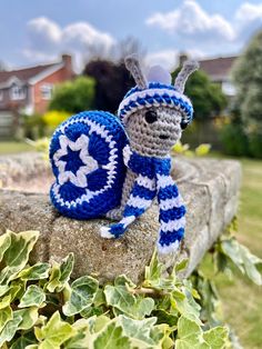 a crocheted stuffed animal sitting on top of a rock