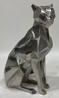 a metal cat sitting on top of a white floor