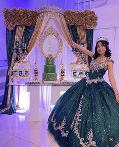 a woman in a green dress standing next to a cake