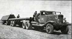 an old black and white photo of a truck with pipes on it's flatbed