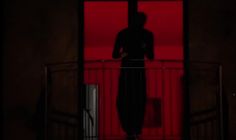 the silhouette of a person standing on a balcony in front of a red wall and railing