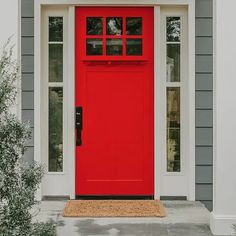 a red front door on a gray house