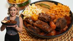 a woman holding a plate of food next to a bowl of rice and other foods