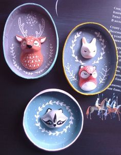 three bowls with animal figurines in them