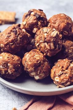 a plate filled with cookies and oats on top of a table next to crackers