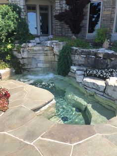 an outdoor swimming pool in the middle of a stone patio with steps leading up to it