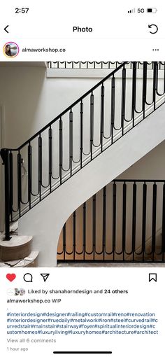 an image of a staircase in the middle of a room with black iron railings