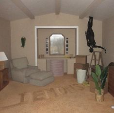 a living room filled with furniture and a cat on top of the carpeted floor