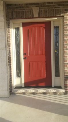 a red front door on a brick house