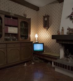 an old fashioned living room with a television and fireplace