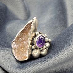 "This is a beautiful rustic and organic ring, an incredible combination of stones. A Druzy of Agate and an Amethyst, enclosed in a special composition. Oxidized and brushed to highlight the surface pattern. Bohemian style inspired by ancient times. This piece is entirely made by myself, soldering sterling silver (925) with traditional Jewelry techniques. Every piece is unique! Ring size: US: 7 1/2 IT: 15 1/2 Top ring size: 1\" x 0,8\" 26 x 20 mm Don't know your ring size? Go here: http://www.onl Fusion Jewelry With Natural Stones Ring, Unique Multi-stone Purple Amethyst Ring, Unique Multi-stone Amethyst Ring, Fusion Style Natural Stone Ring Jewelry, Fusion Style Multi-stone Open Ring Jewelry, Spiritual Freeform Gemstone Jewelry, Unique Purple Multi-stone Amethyst Ring, Fusion Style Natural Stone Ring, Nature-inspired Amethyst Gemstone Jewelry