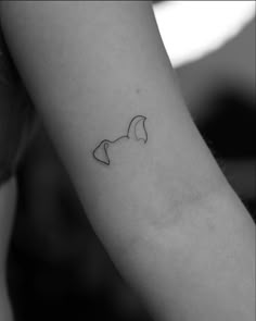 a black and white photo of a woman's arm with a tattoo on it