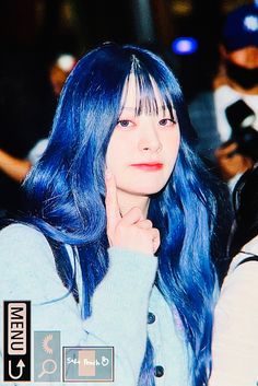 a woman with blue hair is posing for the camera