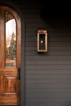 a wooden door and window on a gray house