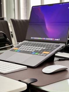 an open laptop computer sitting on top of a desk next to a mouse and keyboard