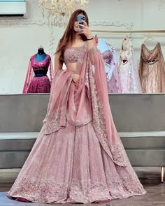 a woman in a pink lehenga taking a selfie