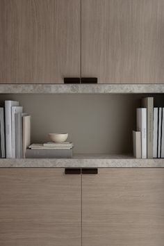 a book shelf with books and a bowl on it