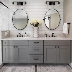 a bathroom with two sinks and three mirrors on the wall next to eachother