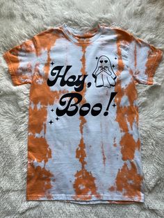 an orange and white tie dye shirt that says hey boo